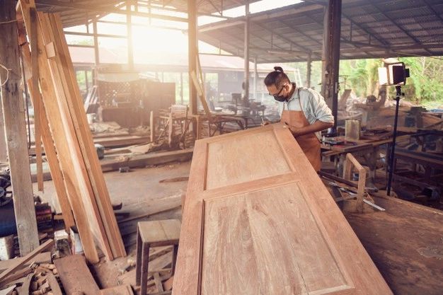 Carpenter fitting a wooden door in a Karachi home