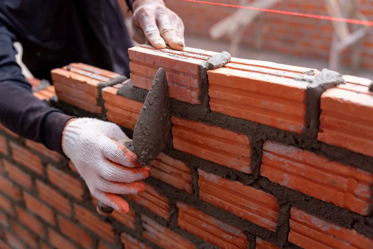 Mason laying bricks for a new wall in Karachi