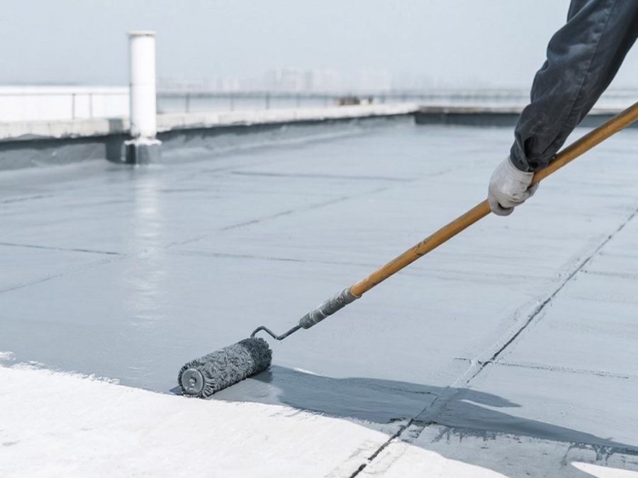 Waterproofing coating being applied with a roller on a rooftop in Karachi